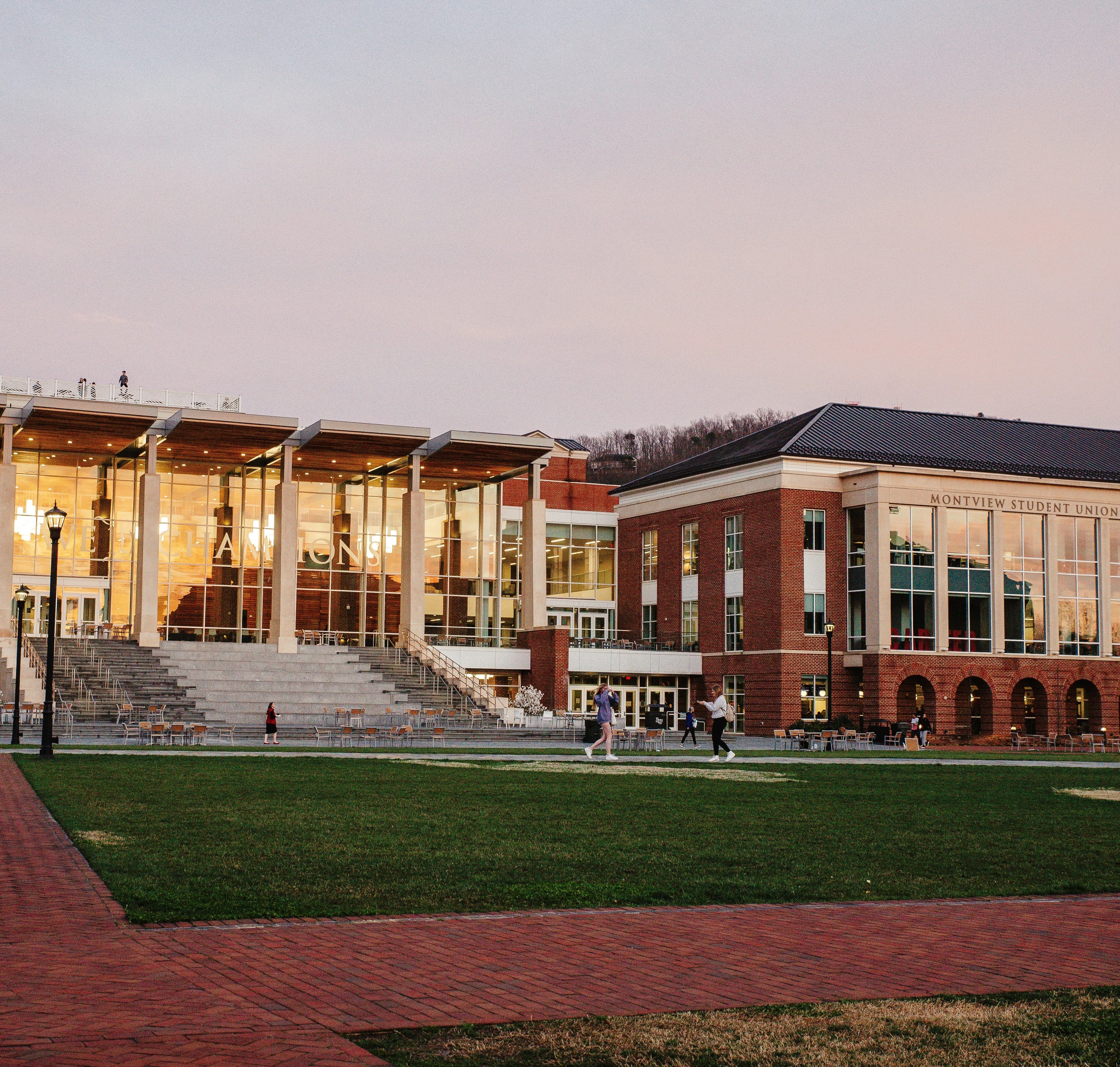 College Campus Facilities and Athletics Modern college campus building with glass windows and brick architecture at dusk